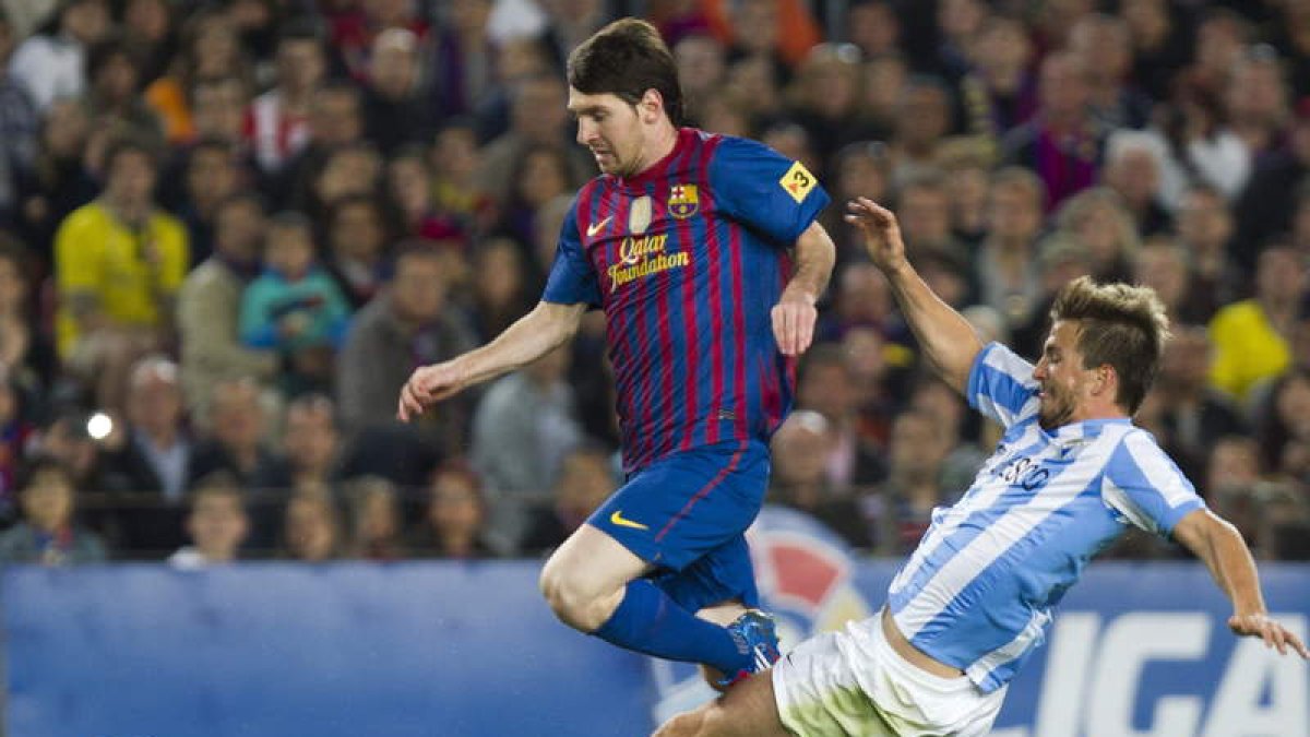 Messi, a la izquierda, pelea un balón con el centrocampista del Málaga Ignacio Camacho.