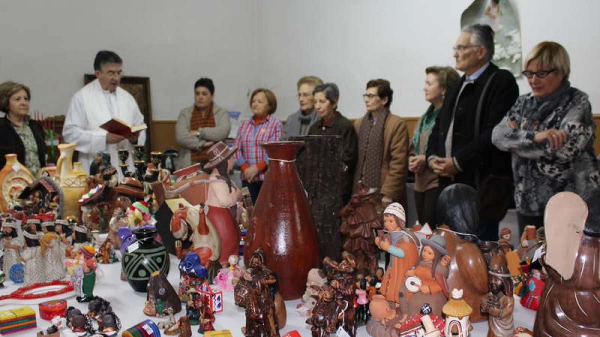 Miembros del voluntariado y el párroco inauguran la cita.