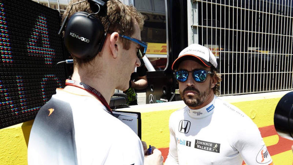 Alonso conversa con sus mecánicos. ALEJANDRO GARCÍA