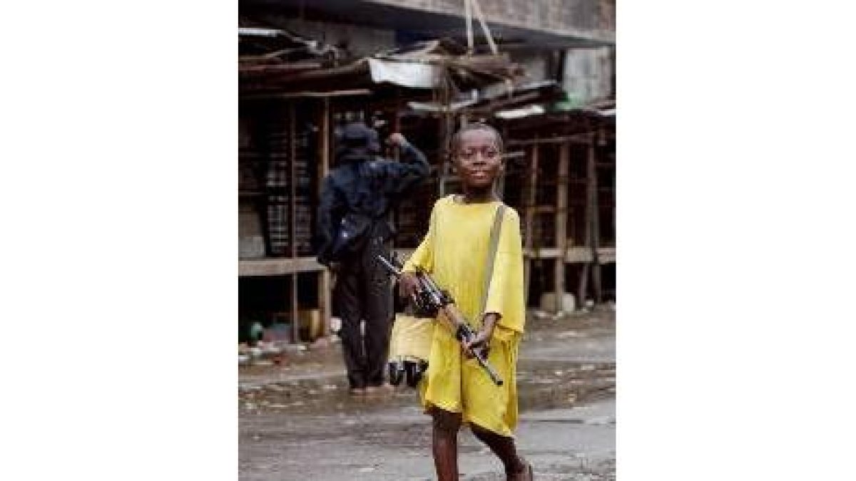 Un niño soldado sostiene un fusil en Liberia
