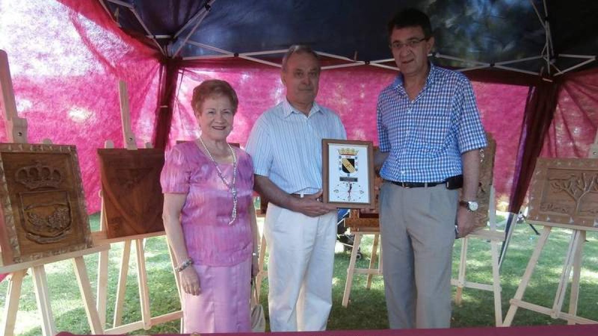 El artesano invitado Manuel Parrado recibe un obsequio de manos del alcalde.