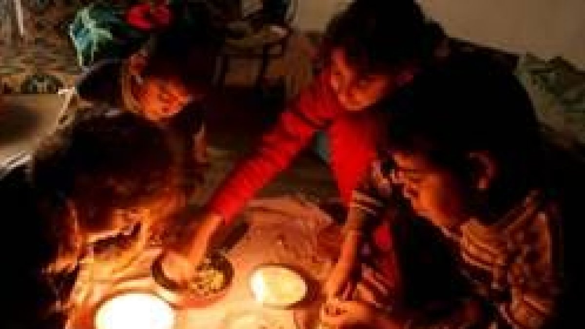 Una familia palestina come a la luz de las velas en la segunda jornada del bloqueo israelí a Gaza