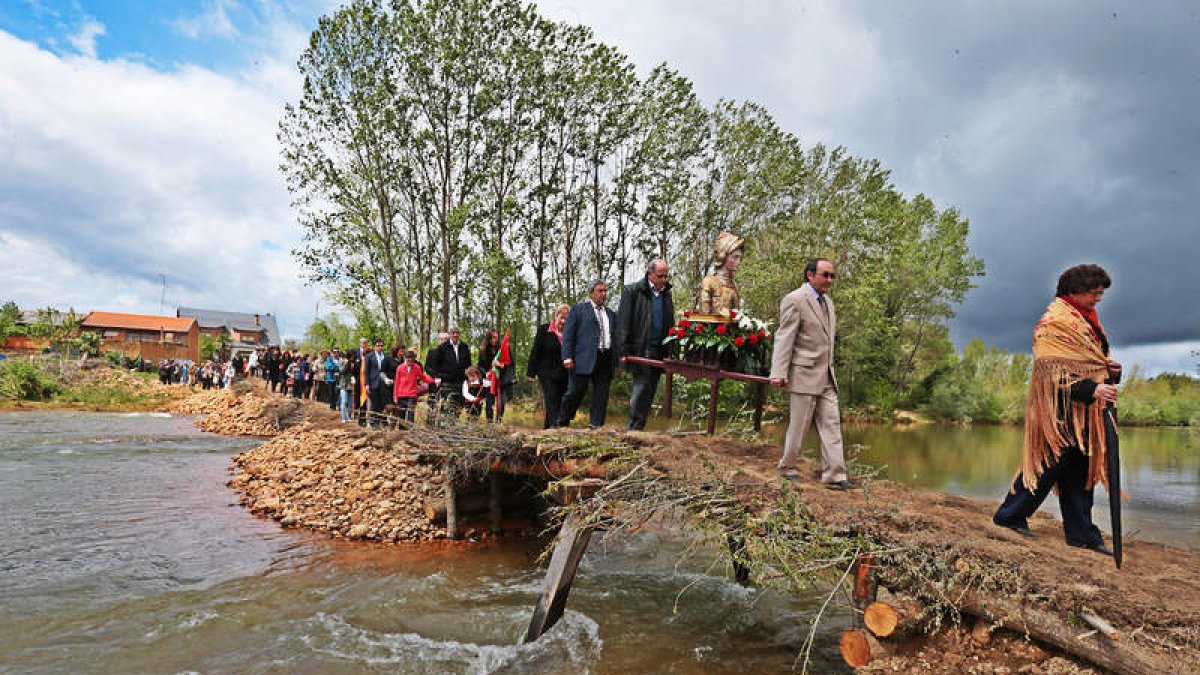 La reliquia de san Jorge cruza el Eria por el puente de palos y piedras.