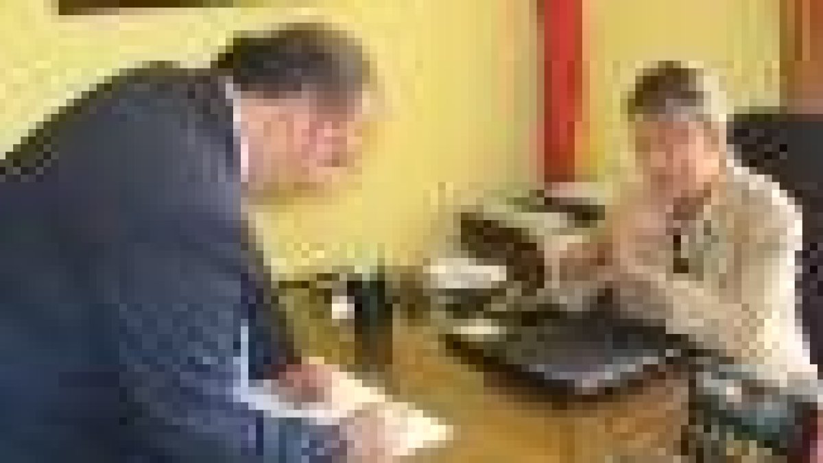 Eduardo Fernández firma en el libro consistorial ante la alcaldesa, Carmen González