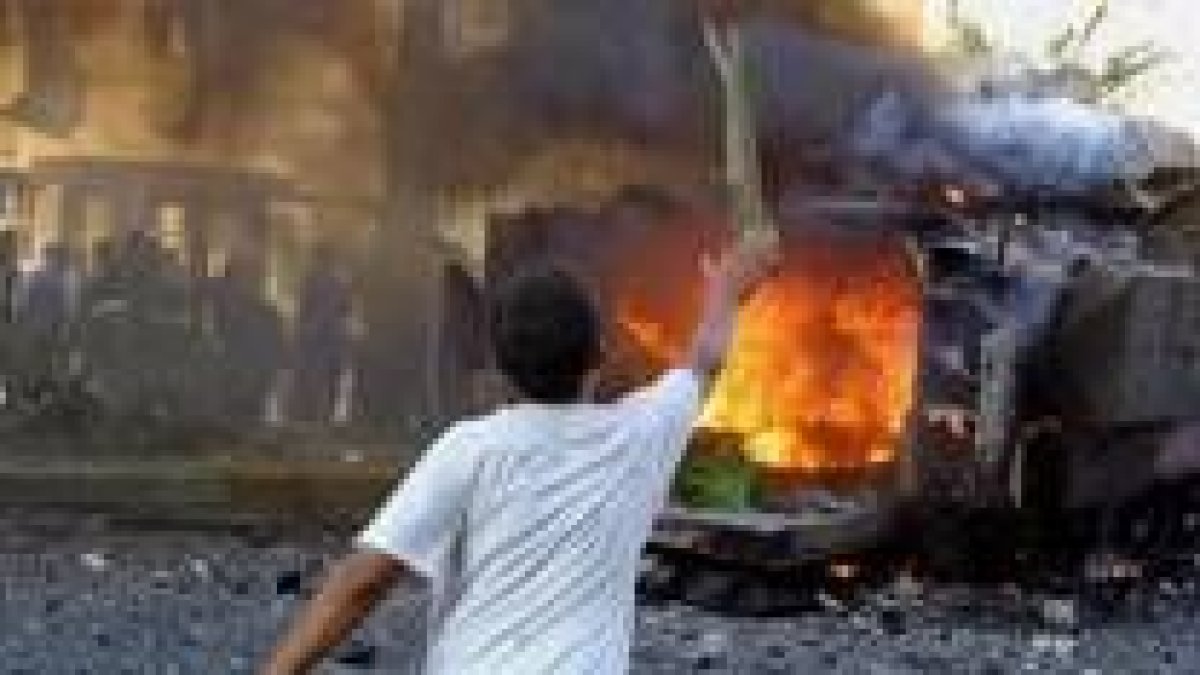 Un niño iraquí presencia cómo el fuego consume un tanque del Ejército norteamericano en Bagdad