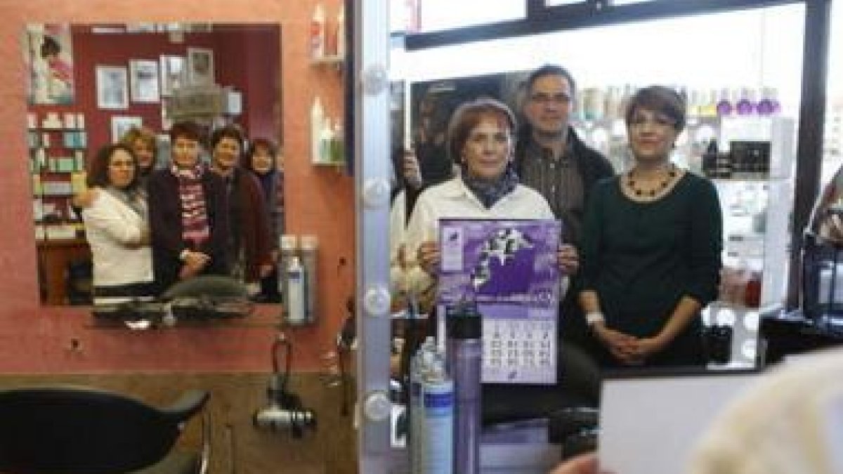 La presidenta de Adavas, Carmen Carlón, sostiene el calendario del 2009. A su lado, María del Mar De