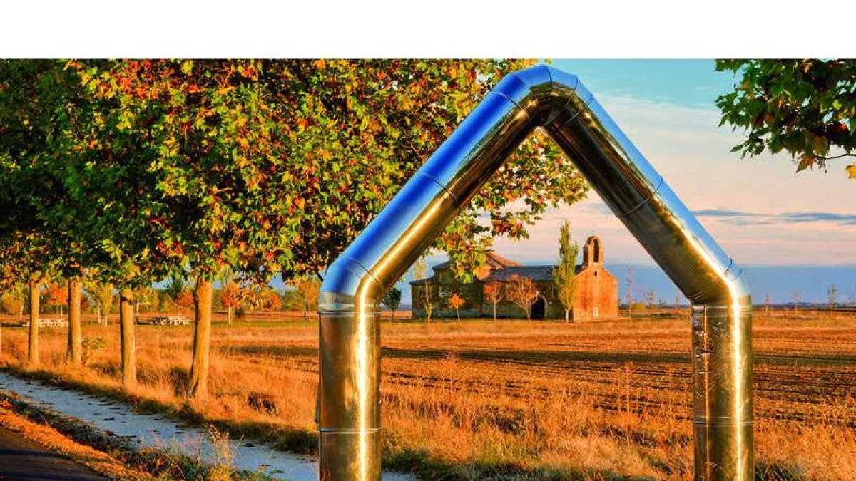 Una de las fotos del libro con la ermita de Perales, en Bercianos del Real Camino, enmarcada por una escultura de Cuenllas. J. ALEGRE