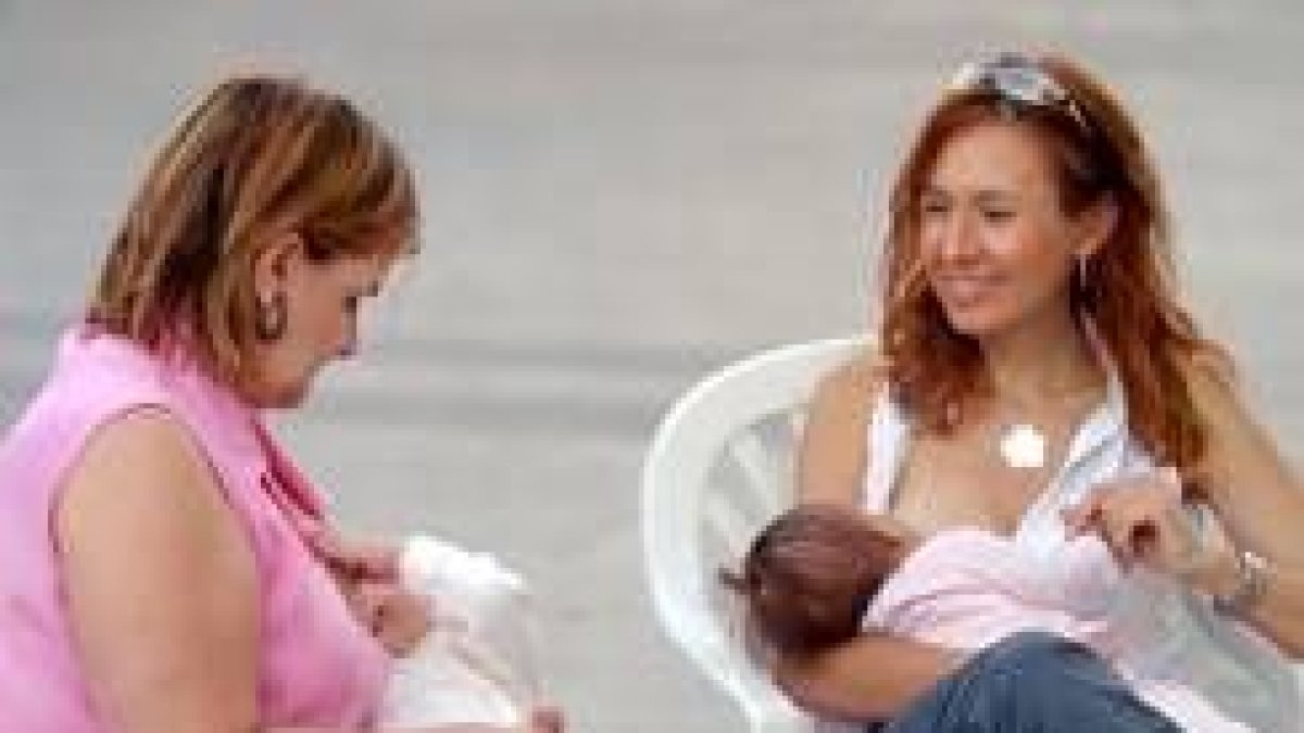 Unas madres defensoras de la lactancia materna alimentan a sus hijos en un acto público