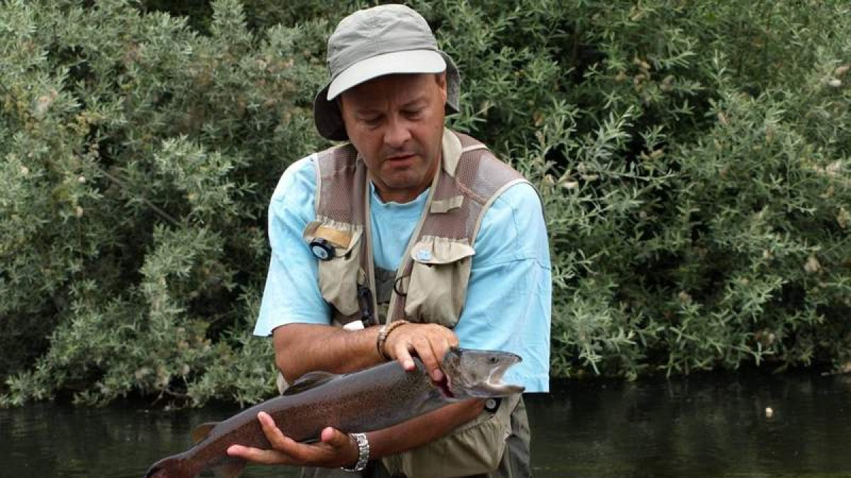 Un pescador sostiene un hucho de buen tamaño.