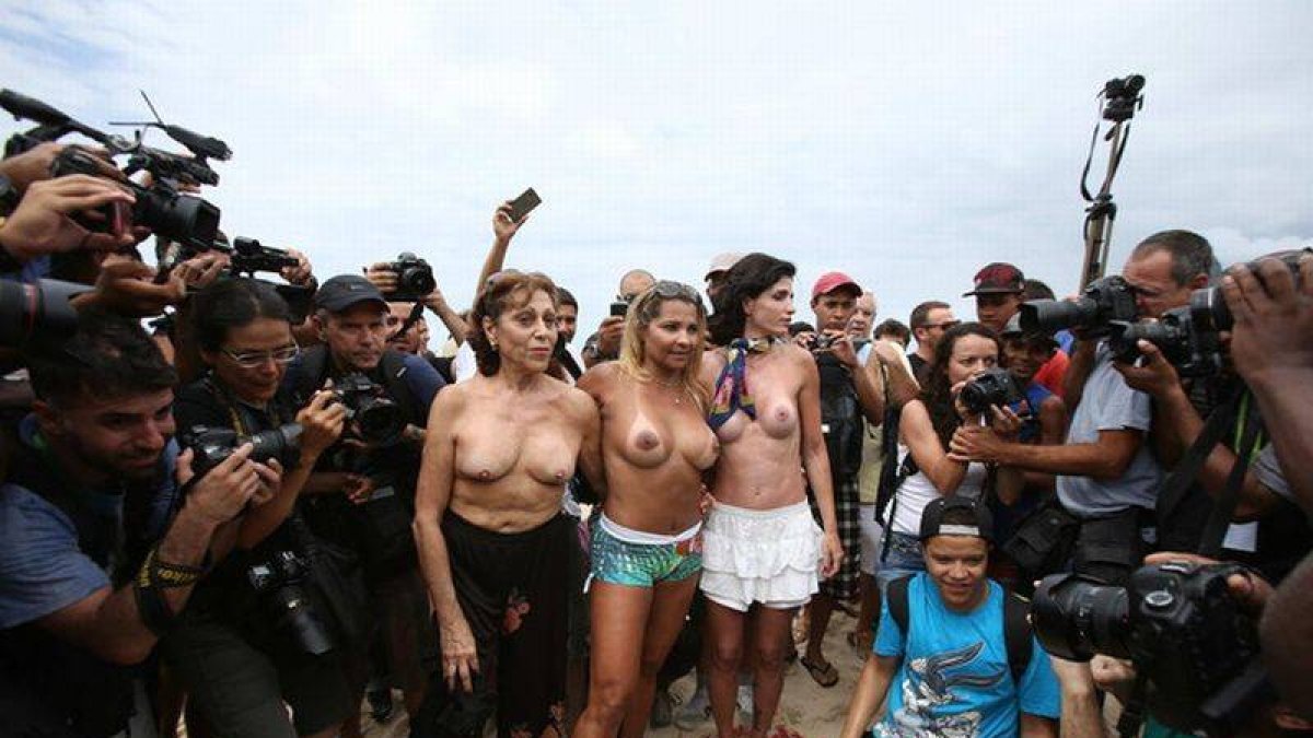 Tres mujeres con los senos desnudos posan para fotógrafos y camarógrafos durante la protesta para exigir la legalización del 