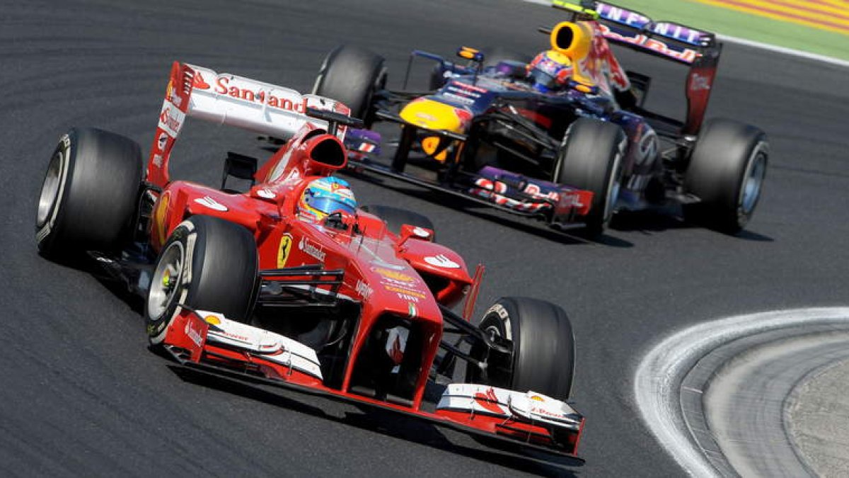 El español Fernando Alonso pugna con su Ferrari con el piloto de Red Bull, Mark Webber, durante el Gran Premio de Hungría disputado ayer.
