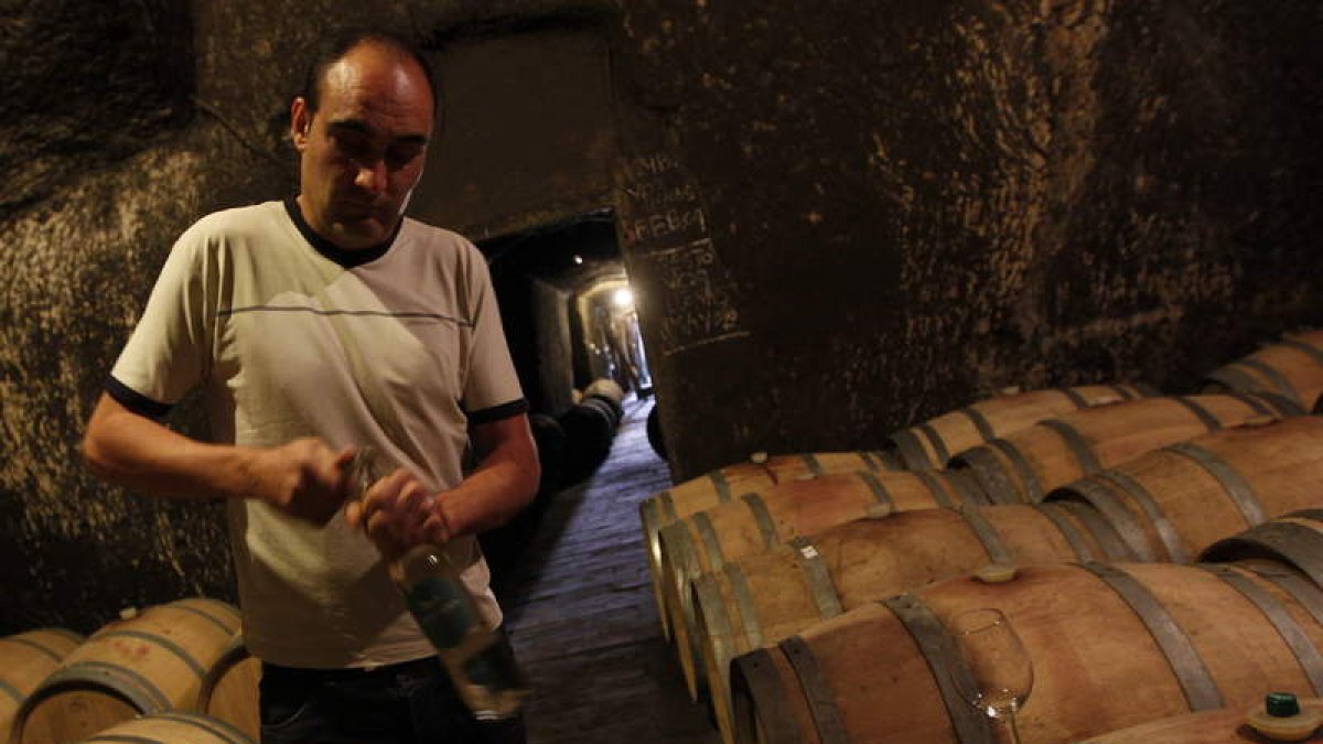 Rafael Alonso descorcha una botella de blanco en la bodega tradicional en la que duermen los tintos de Pardevalles.