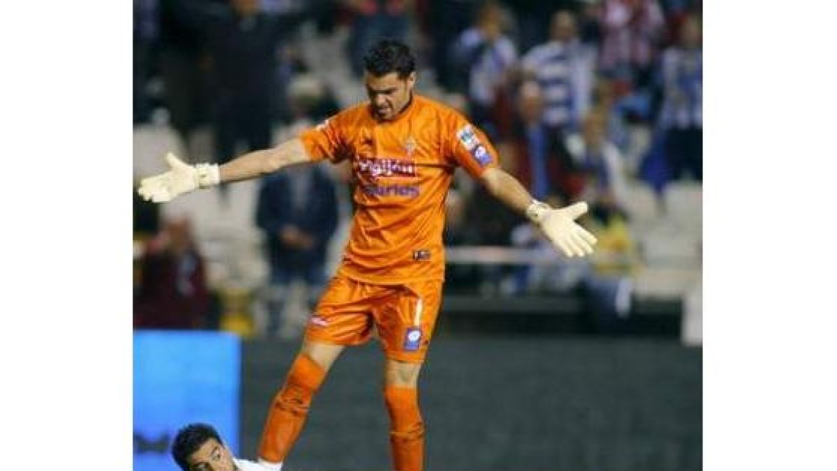 Riki, del Deportivo, permance en el suelo junto al meta leonés del Sporting, Juan Pablo.