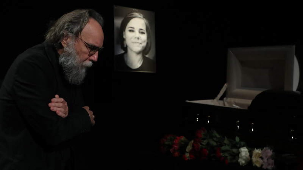 Alexander Dugin ayer en el funeral de su hija en Moscú, ante un retrato y la caja con su cadáver. MAXIM SHIPENKOV