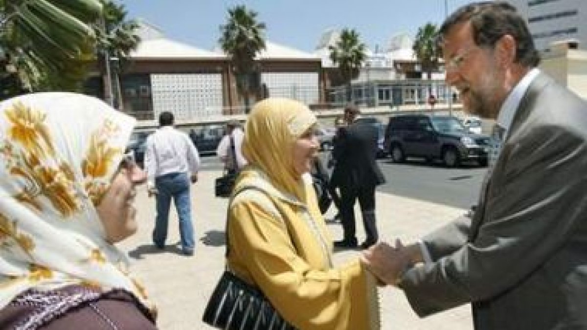 El presidente del PP, Mariano Rajoy, saluda a una mujer en Melilla