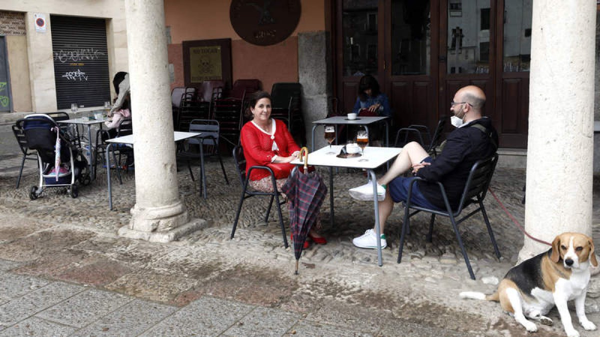 Clientes de un negocio hostelero capean la tormenta bajo el soportal de la terraza. MARCIANO PÉREZ