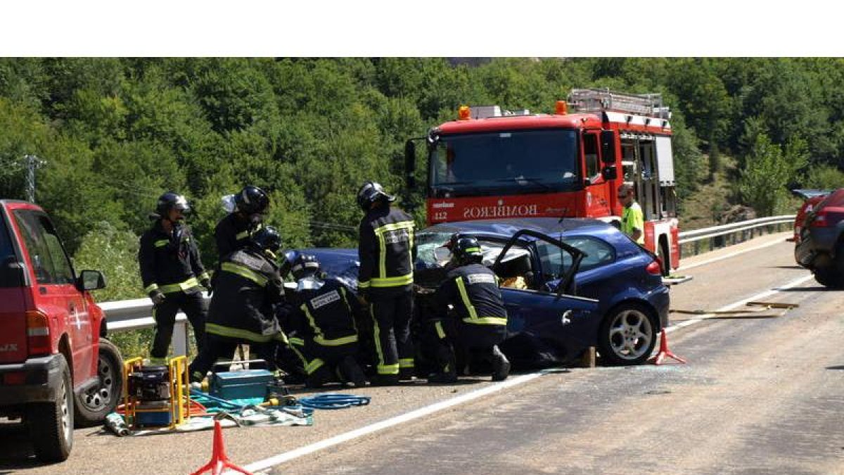 Los bomberos trabajan para recuperar el cuerpo de uno de los conductores de su vehículo