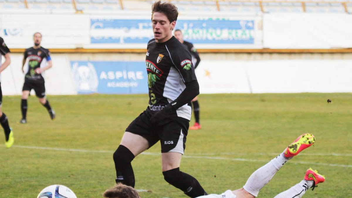 Juan Bardal ante dos jugadores del Tudelano en un lance del partido. SECUNDINO PÉREZ