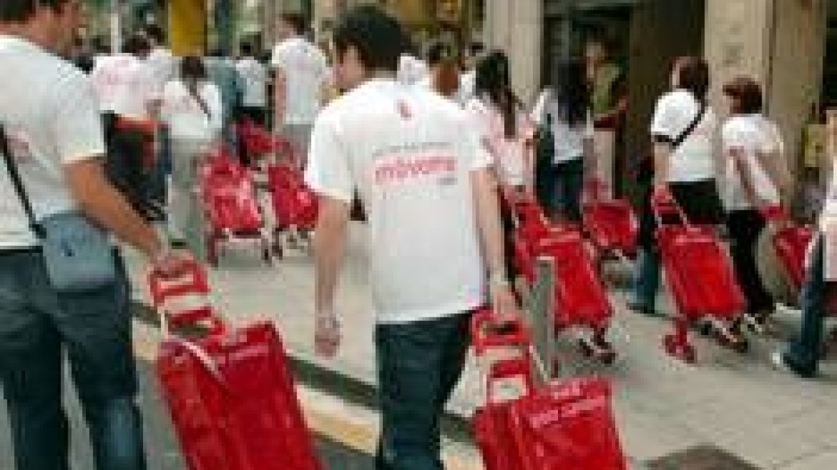 Un grupo de agentes electorales del PSOE, provistos de carros, reparten propaganda electoral
