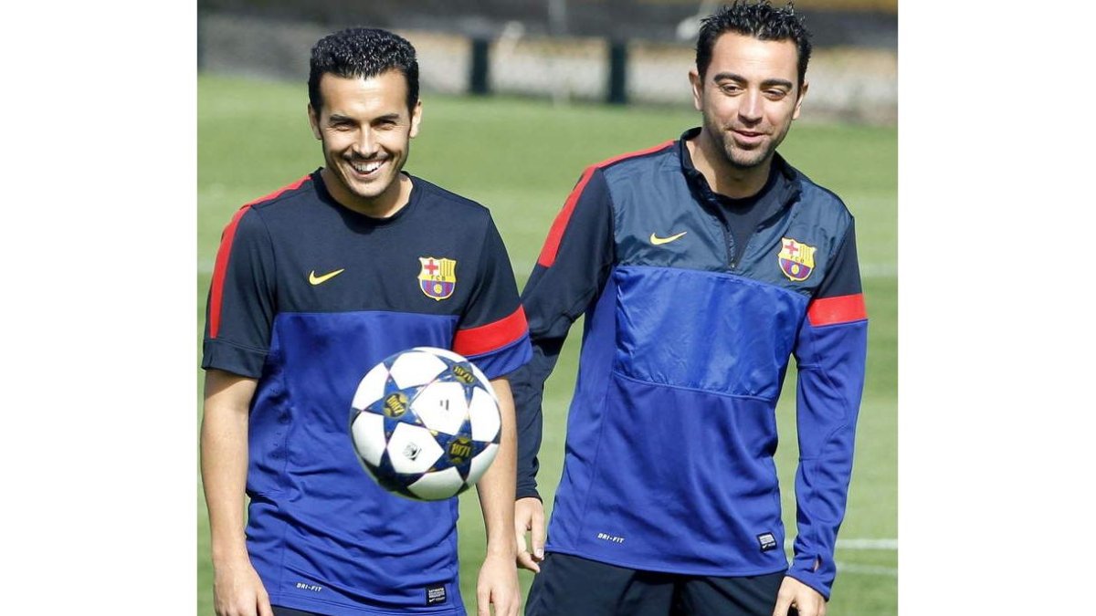 Los jugadores del Barcelona, Pedro y Xavi Hernández, durante el entrenamiento realizado ayer.