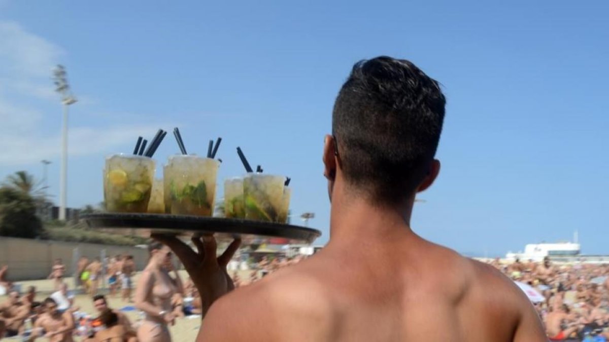 Un camarero en un chiringuito de la playa de la Mar Bella de Barcelona.