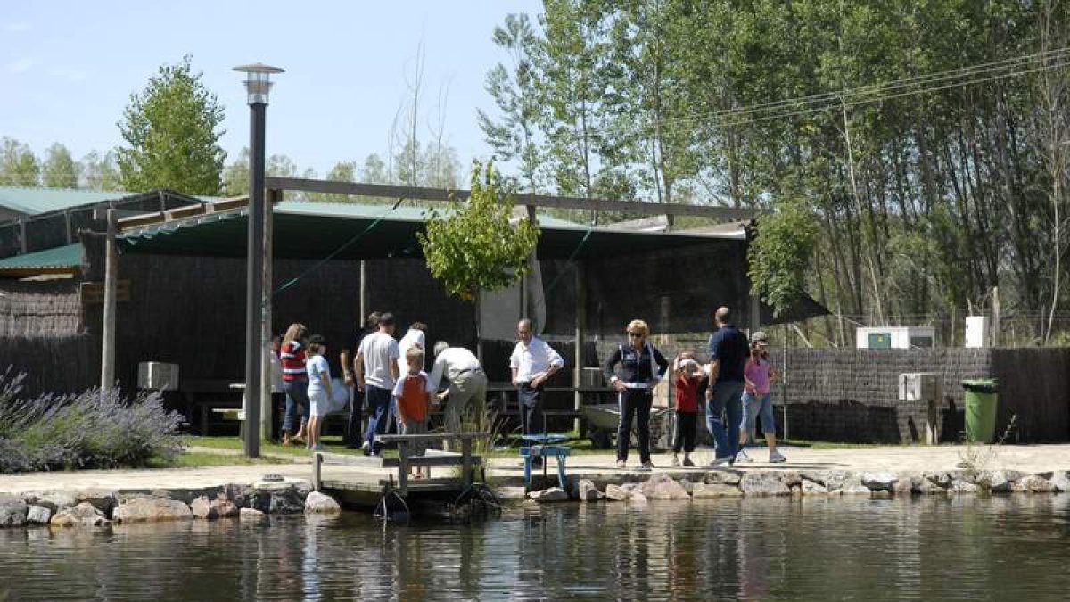 Un grupo de visitantes, en el lago donde se practica pesca sin muerte en el Aula del Río situada en Vegas del Condado. JAVIER