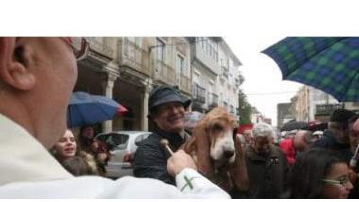 El cura de Cacabelos, Jesús Álvarez, bendice a uno de los perros con su dueño ayer por la mañana en