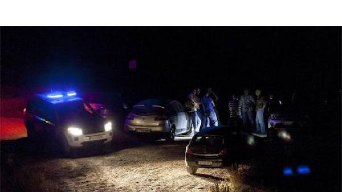 Varios coches de policia en la zona donde se encontraron los cuerpos.