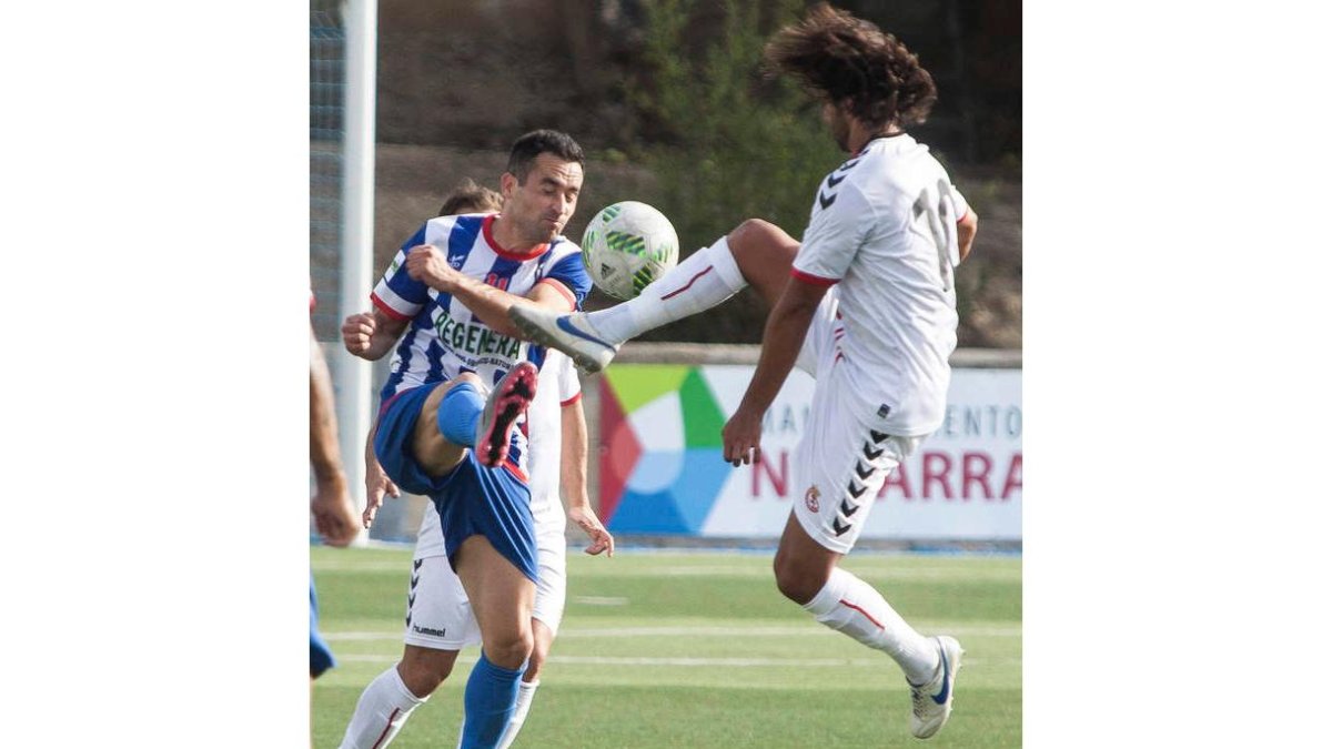 El culturalista Mario Ortiz, a la derecha, pugna por el balón con el rival Javi Briñol. JOSÉ ZABALZA