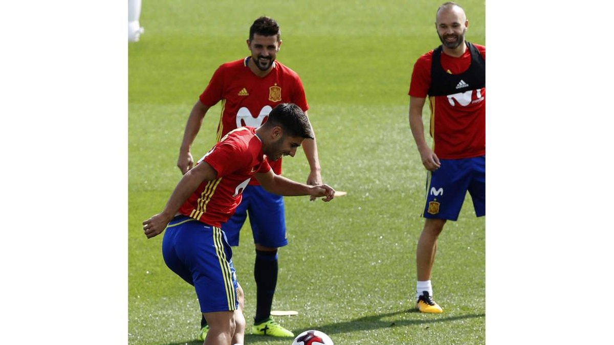 Marco Asensio (i), David Villa (i, arriba) y Andrés Iniesta (d) durante el entreno de ayer. JUAN CARLOS HIDALGO