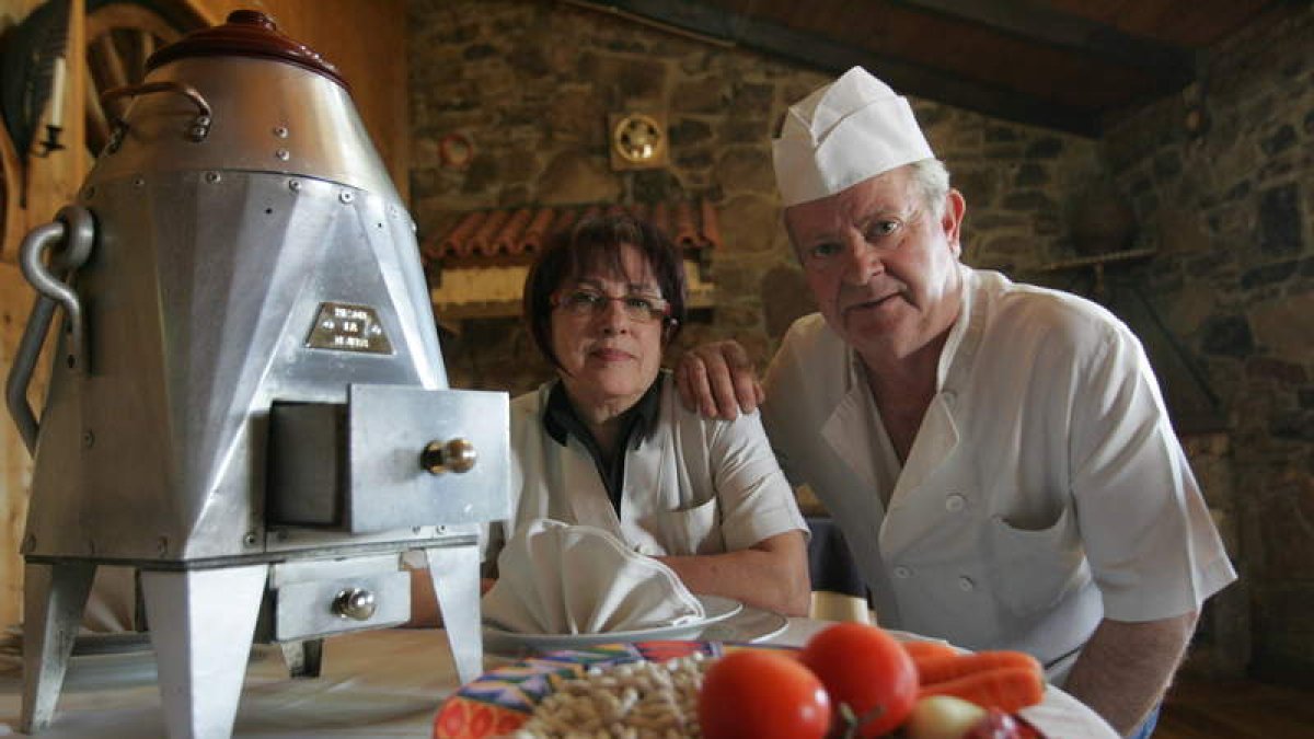 María Lucía y Ángel junto con la tradicional y casi desaparecida olla ferroviaria que ellos han recuperado y donde preparan su plato estrella.