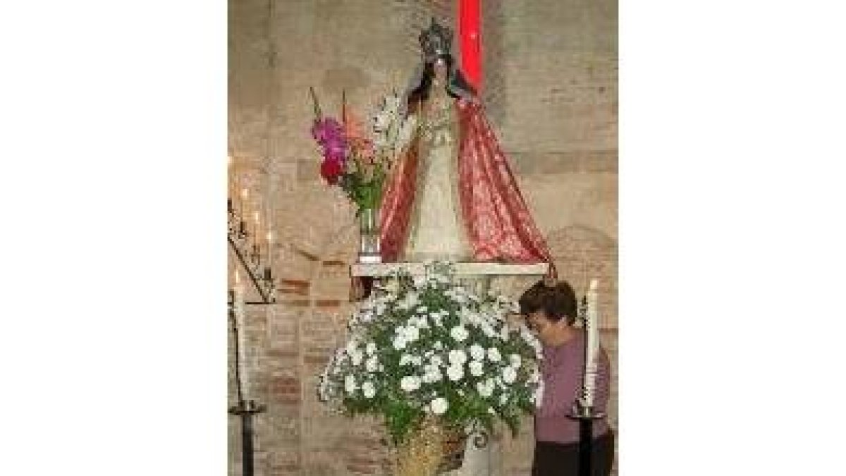 Julia Tovar alisa el vestido de la Virgen del Puente