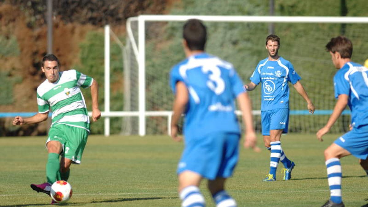 El jugador de La Virgen, Mario Villar, intenta un pase ante la poblada defensa de La Granja.