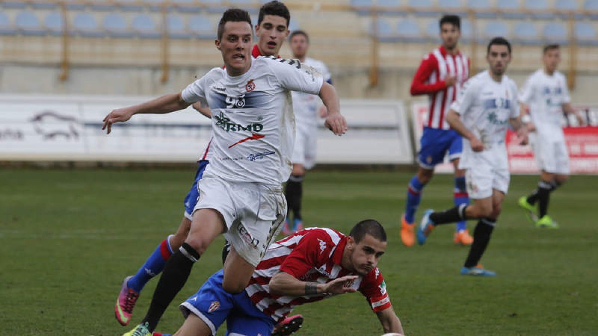 Adán Gurdiel se lleva el balón durante el partido frente al Sporting de Gijón B en el estadio Reino de León.