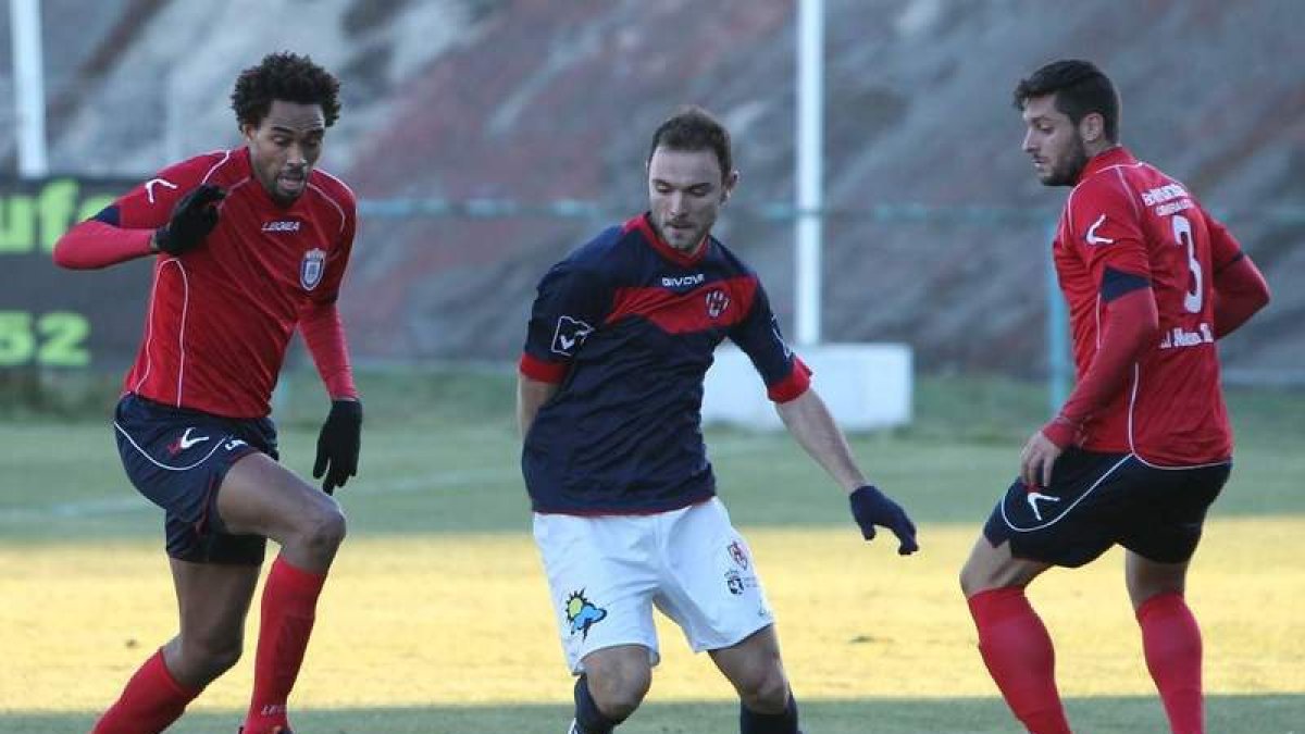 Joshua, en el centro, se lleva el balón a pesar de la oposición de Rui, izquierda, y Trujillo.