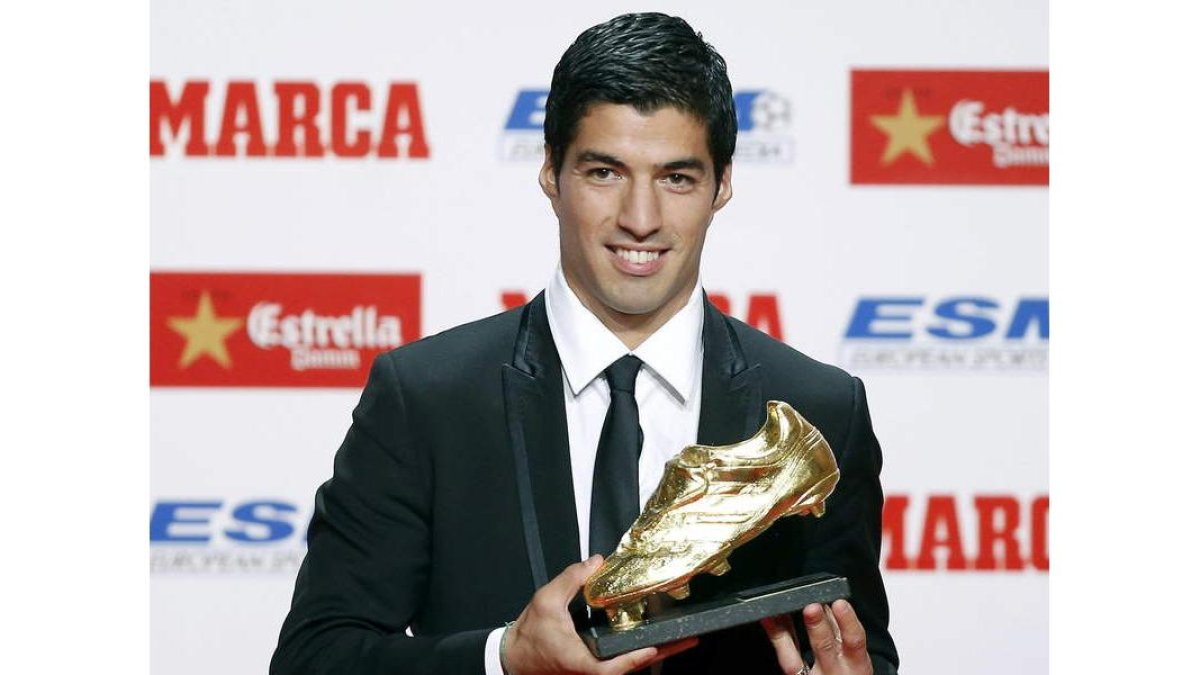 El delantero uruguayo del Barcelona Luis Suárez muestra la Bota de Oro de la temporada 2013-14