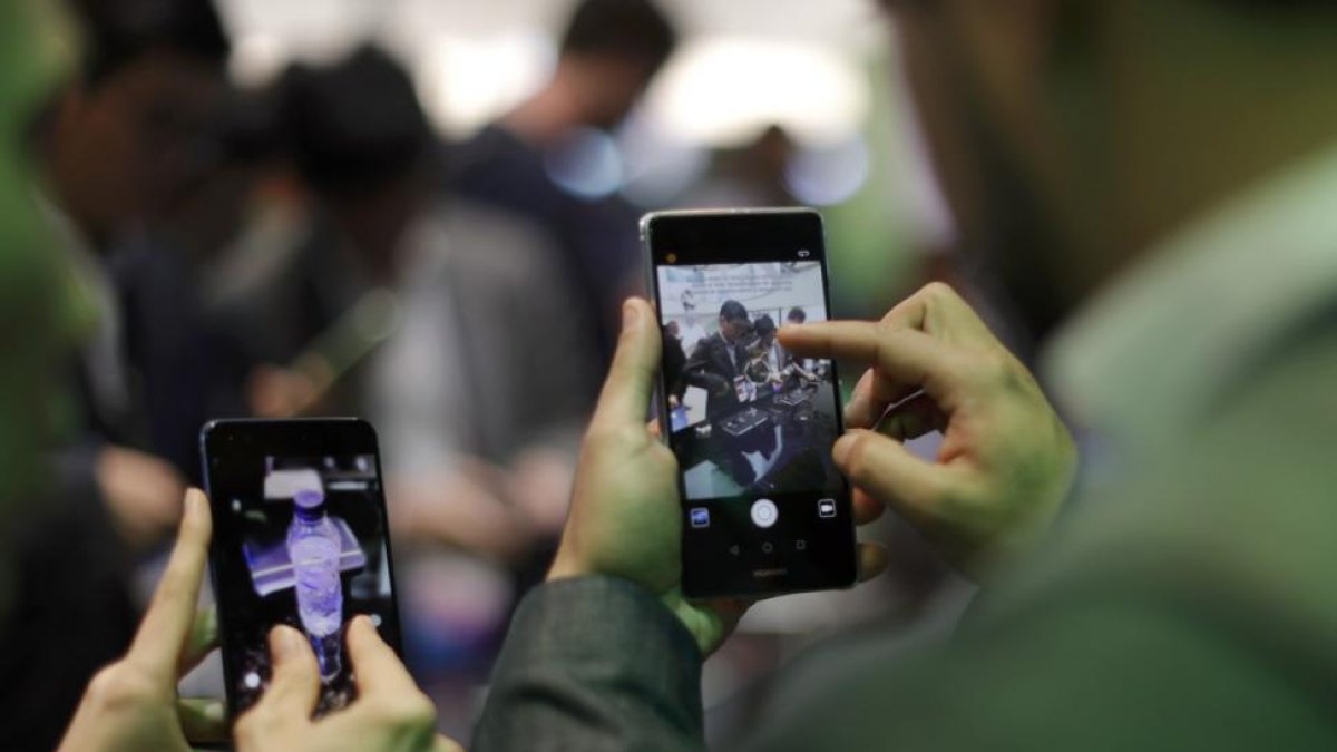 Dos personas manejan sus móviles en el Mobile World Congress de Barcelona, el pasado 27 de febrero.