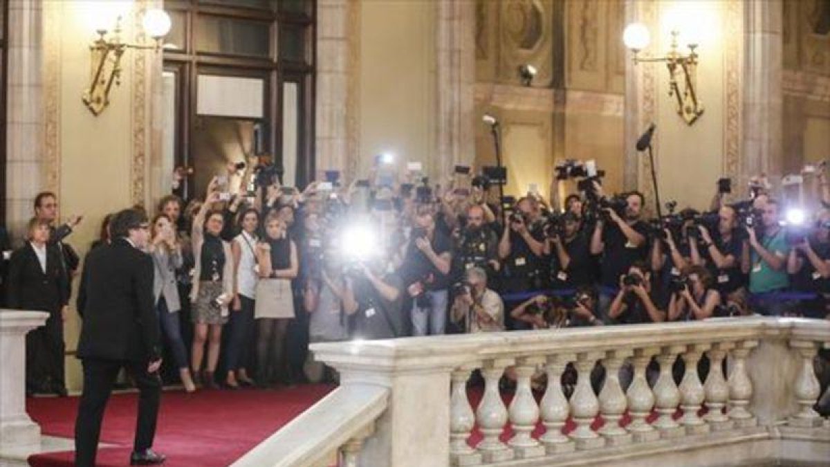 Puigdemont llega al Parlament entre una nube de fotógrafos, el martes, antes de su comparecencia en el pleno.