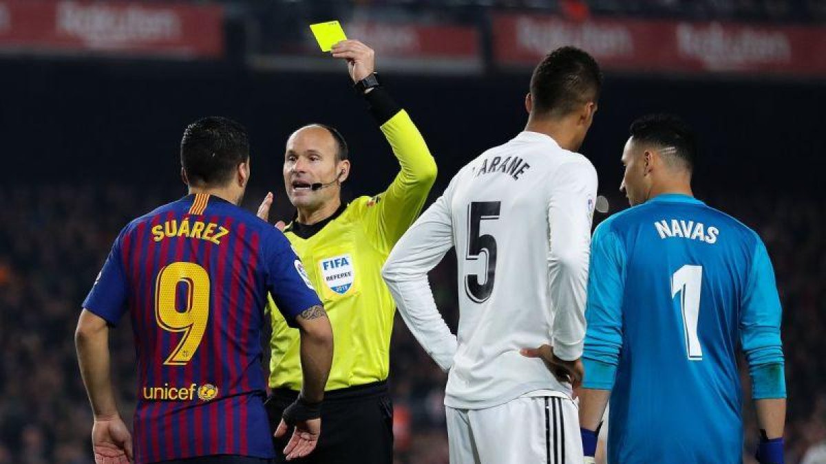 Mateu Lahoz muestra la tarjeta amarilla a Luis Suárez, en el clásico de Copa de la semana pasada.