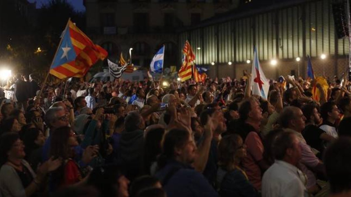 Simpatizantes de Junts pel Sí, este domingo, frente al Born Centre Cultural, donde la candidatura ha organizado el seguimiento de la noche electoral.