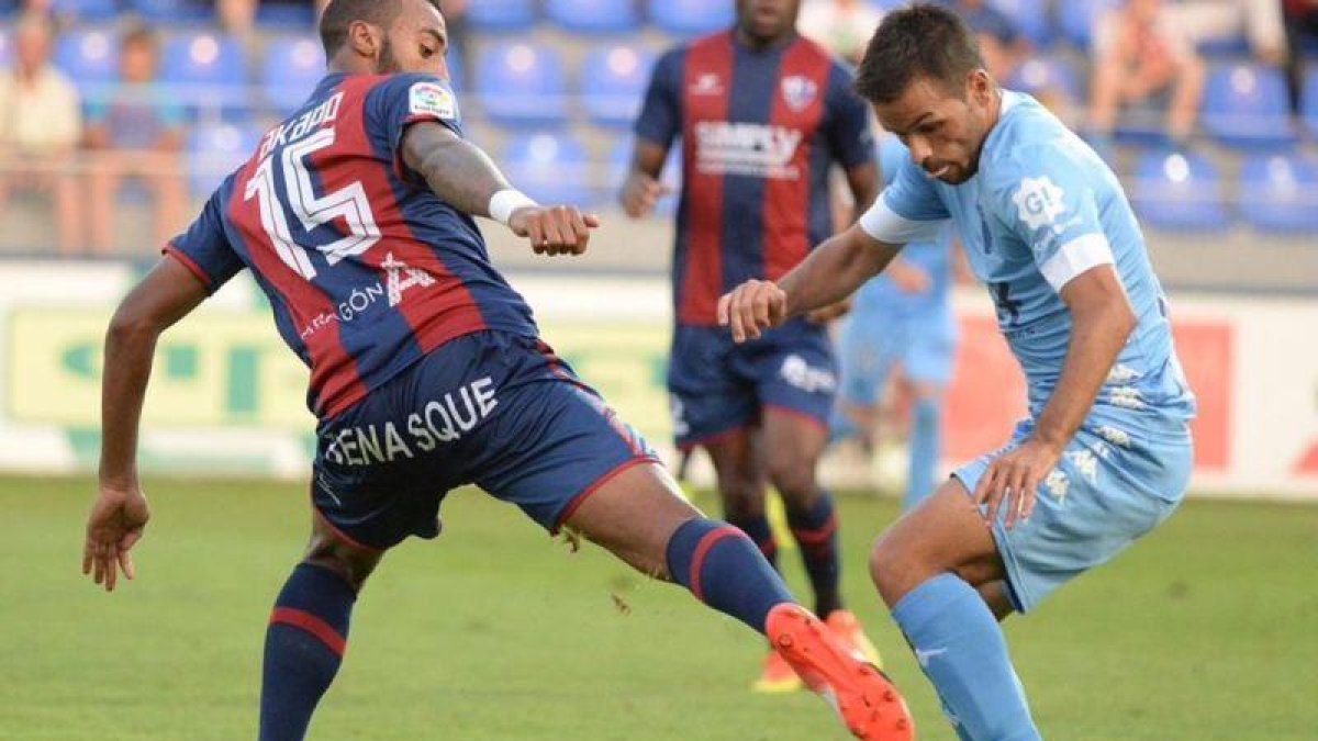 El jugador del Girona, Felipe Sanchón, trata de marcharse del defensa del Huesca, Carlos Akapo.