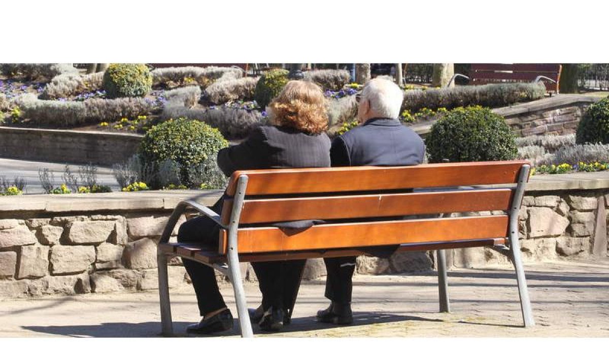 Dos personas mayores descansan en un banco en uno de los parques de la capital.