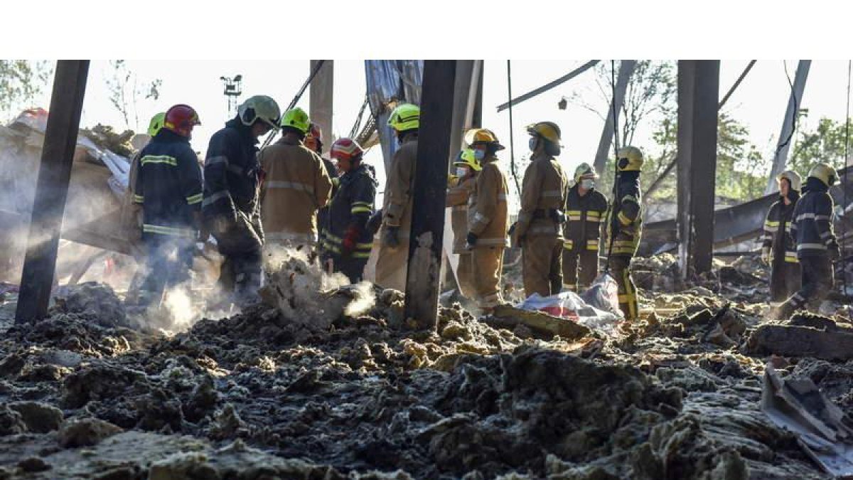 Imagen de los bomberos y servicios de rescate en el centro comercial bombardeado el lunes. OLEG PETRASUHG