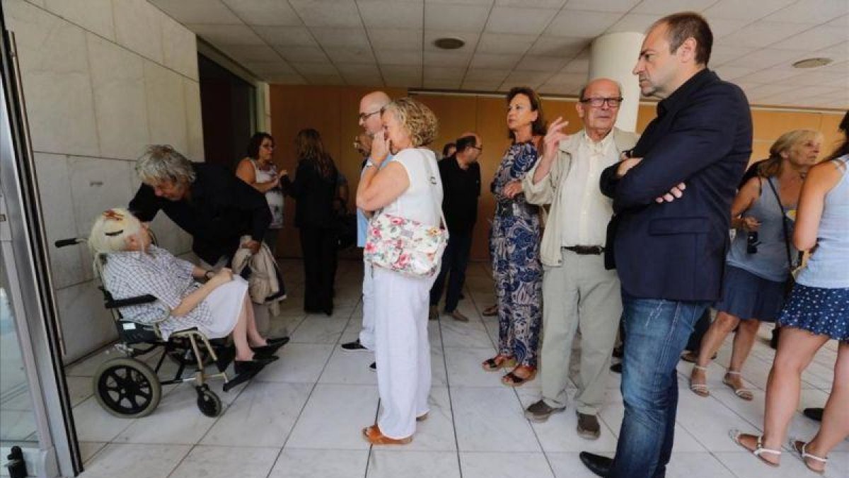 Paco Ibáñez se despide de la viuda de Víctor Mora en presencia de Francisco Ibáñez y del directivo del Grupo Zeta Román de Vicente (derecha).