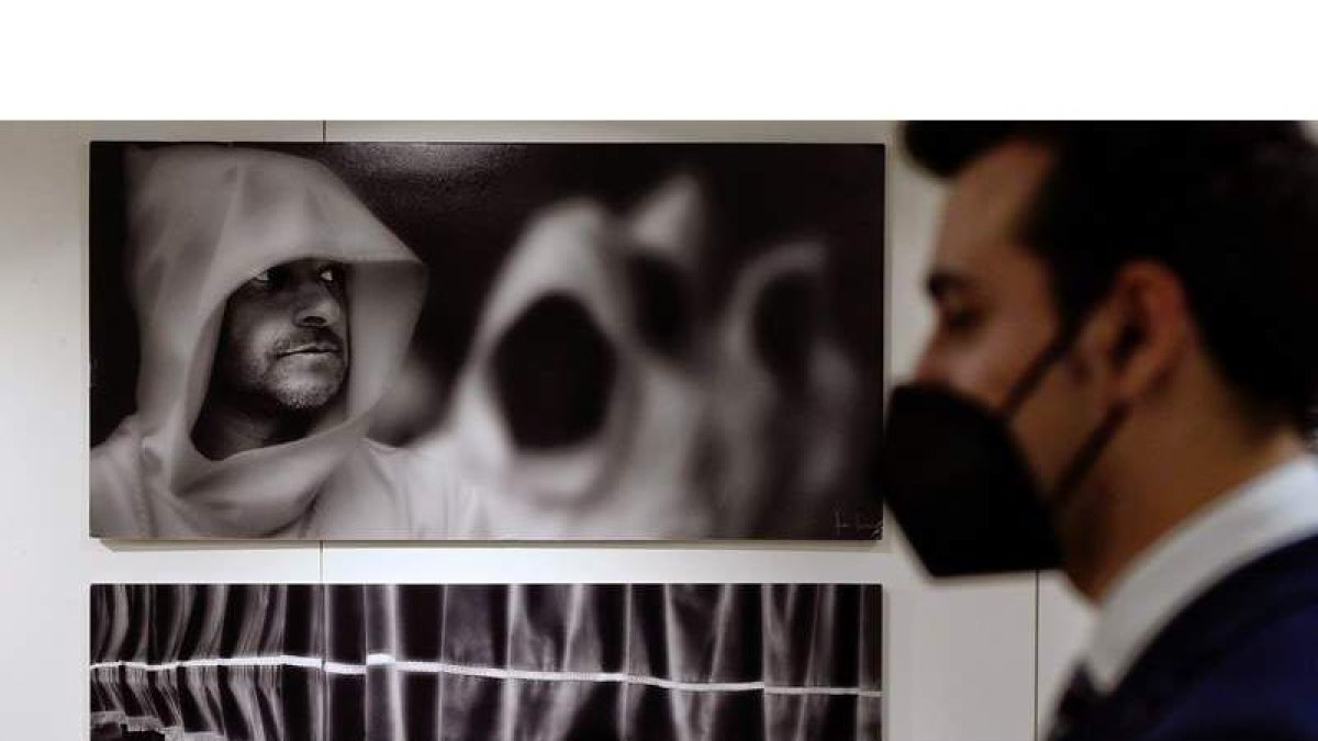 Un hombre observa ayer las fotografías de la Semana Santa en una exposición en CyL. NACHO GALLEGO