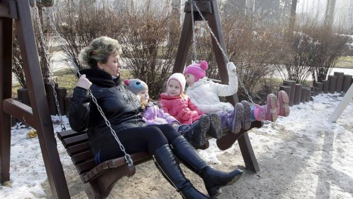 Una mujer y tres niños disfrutan del día de sol, sin bombas, en Donetsk.