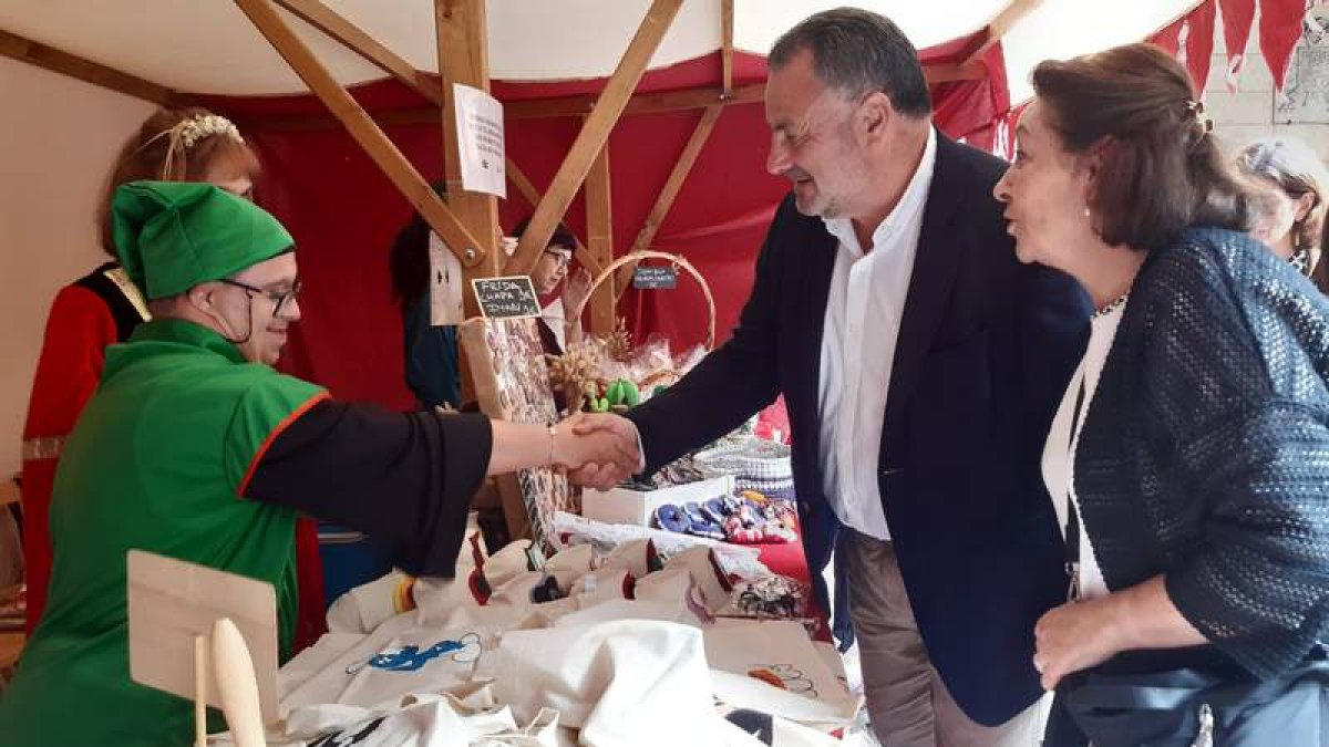 Eduardo Morán y Carolina López saludan a uno de los participantes de la Fiesta Medieval. DL