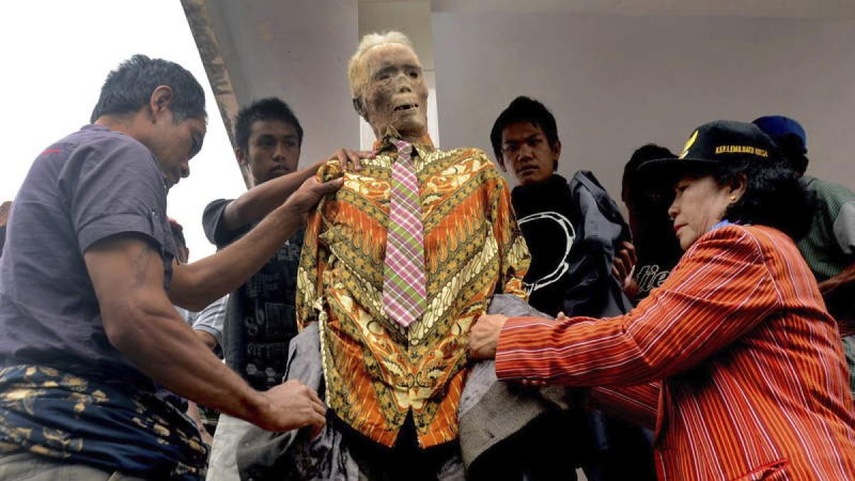 La familia viste al difunto a la espera de que se celebre el funeral. ANDI SAMUDRA