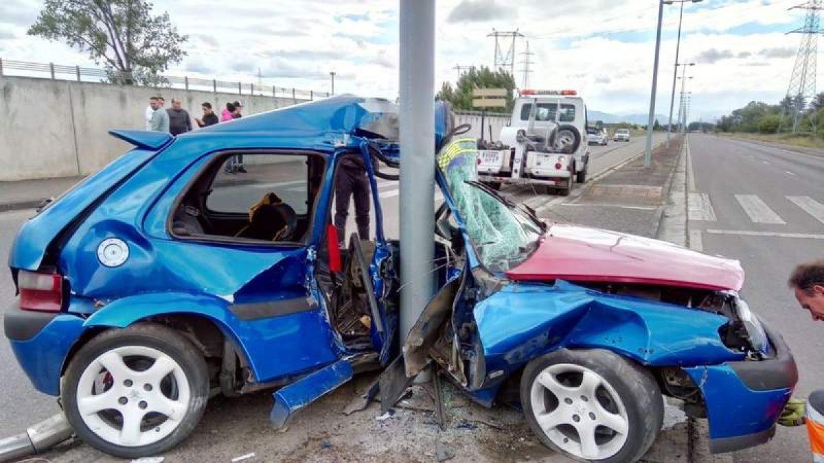 El Citröen Saxo con dos jóvenes de 19 y 21 años quedó empotrado contra una farola. CORTESÍA BOMBEROS