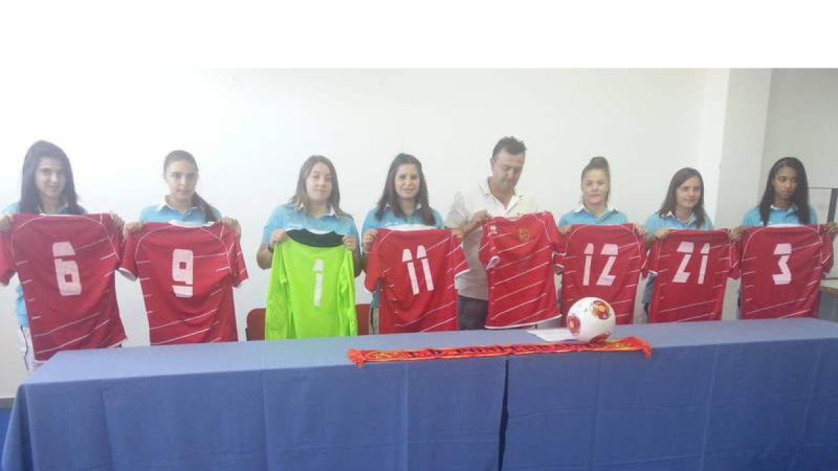 Las nuevas jugadoras del club rojo posan con sus camisetas.